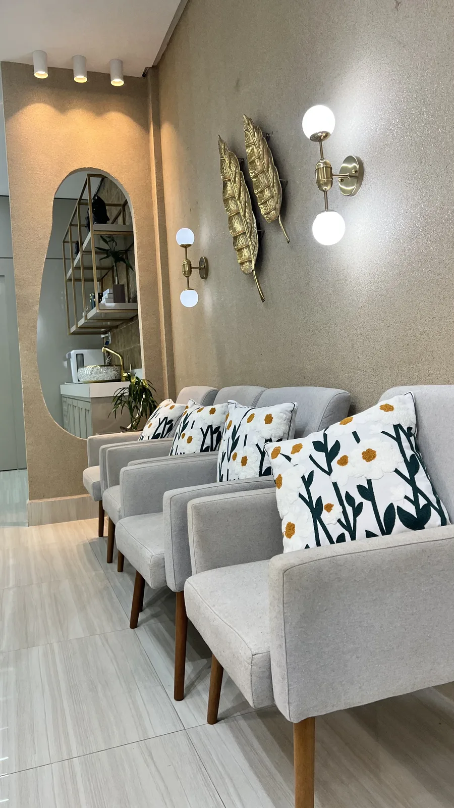 Recepção da clínica com poltronas e espelho de moldura orgânica